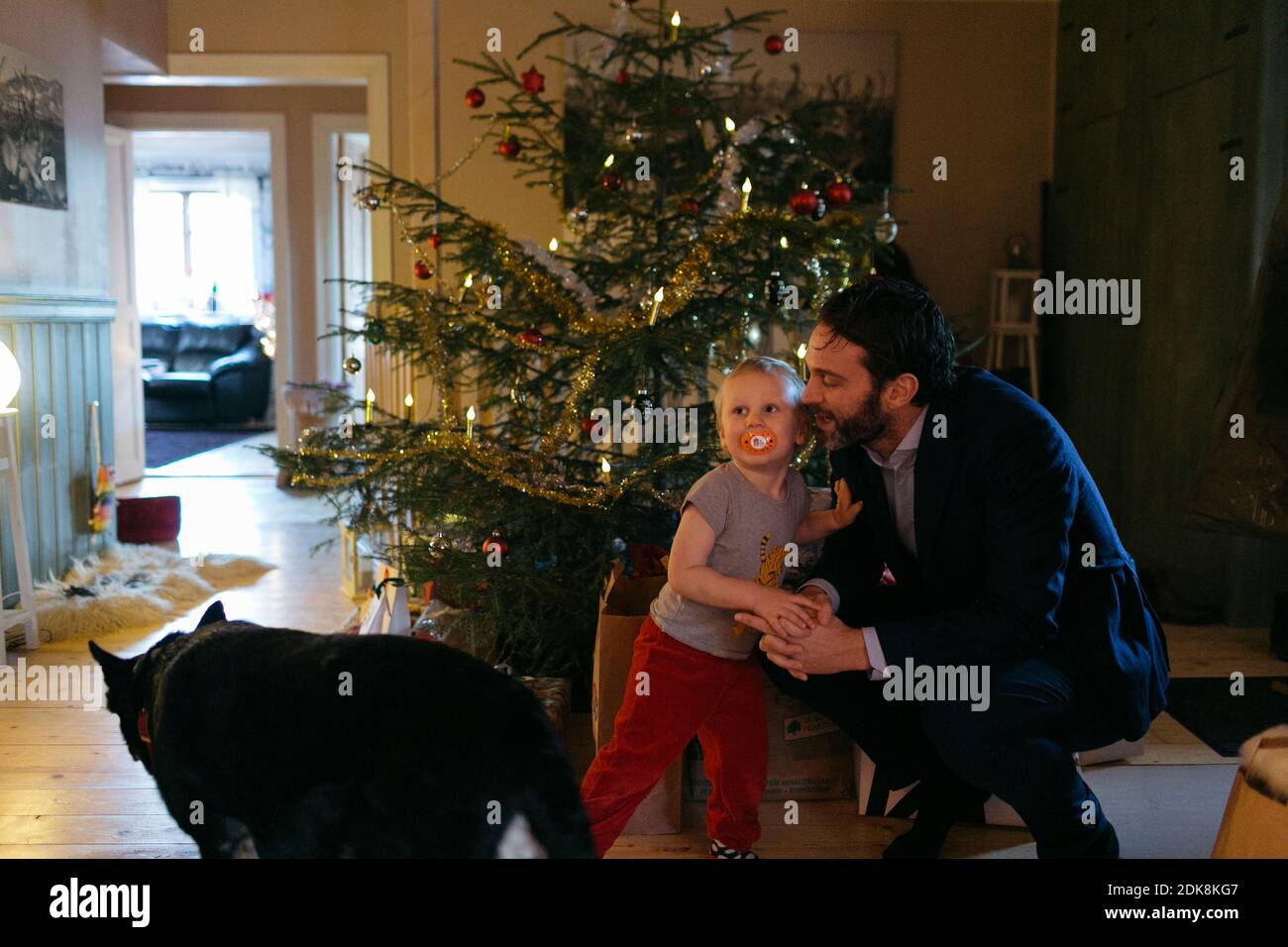 Father with toddler son in front of Christmas tree Stock Photo