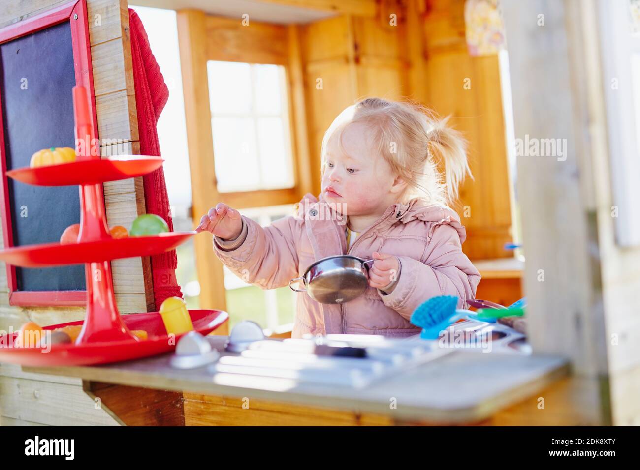 Toddler girl playing in playhouse Stock Photo Alamy