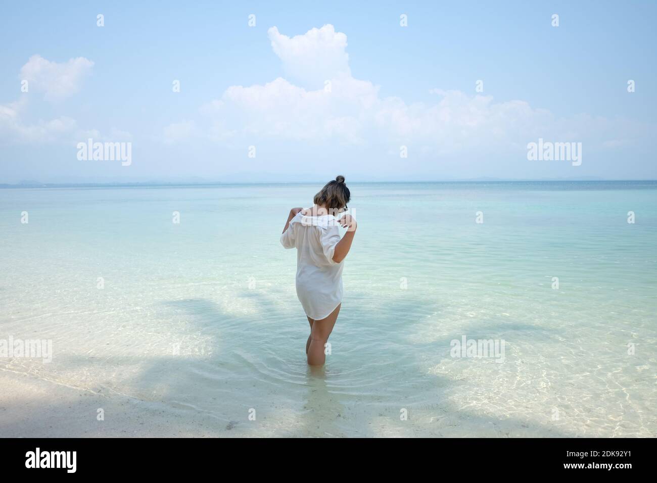 Woman Standing On Shore At Beach Against Sky Stock Photo
