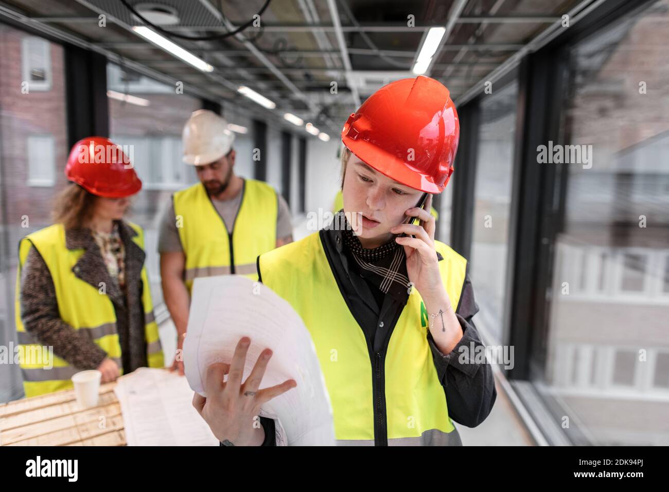 Female construction worker looking at blueprints Stock Photo