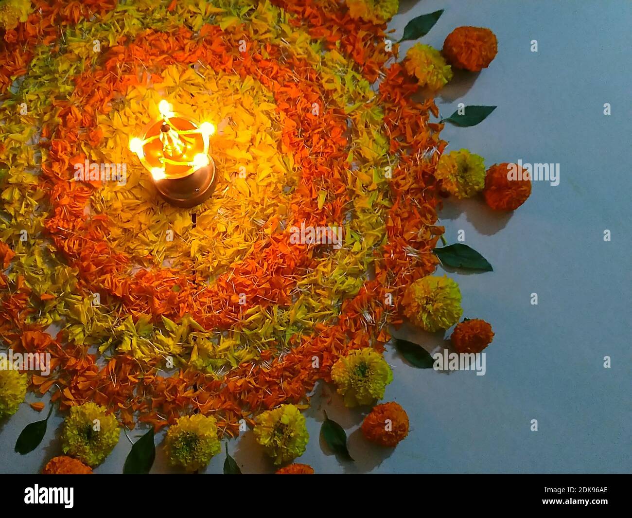 Onam pookalam/floral carpet with lit brass oil lampOnam festival