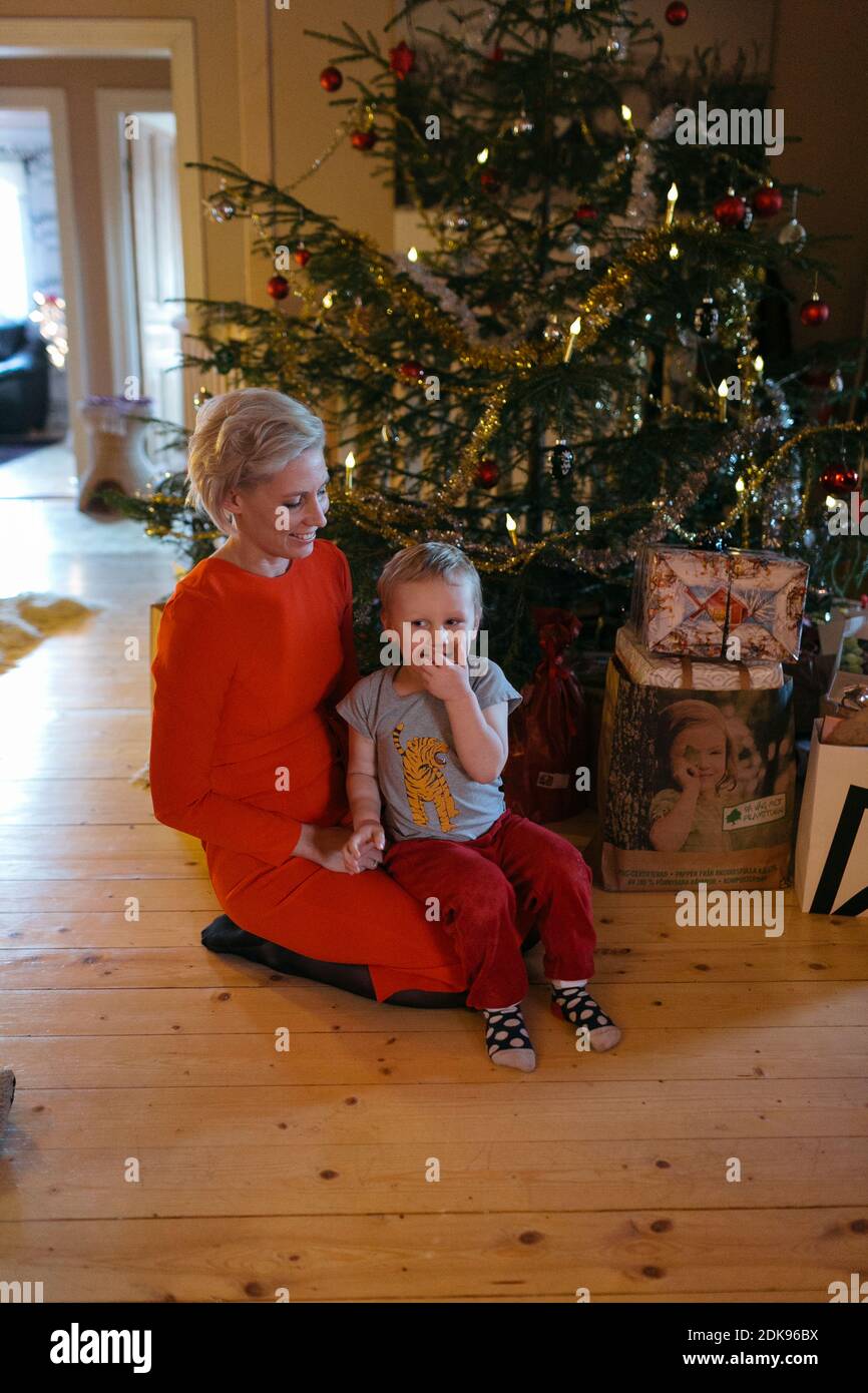 Mother with toddler son in front of Christmas tree Stock Photo