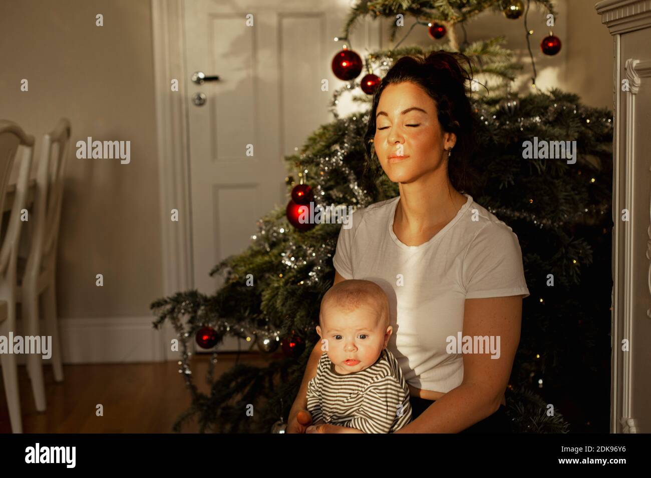 Mother with baby in front of Christmas tree Stock Photo