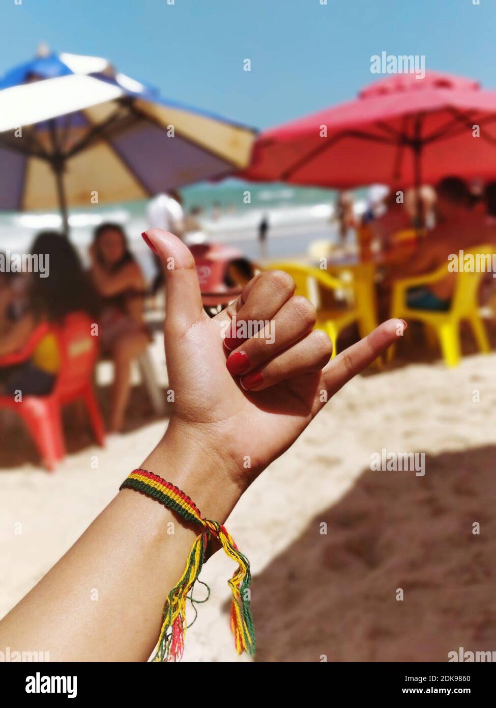 Close-up Of Hand Showing Shaka Sign At Beach Stock Photo