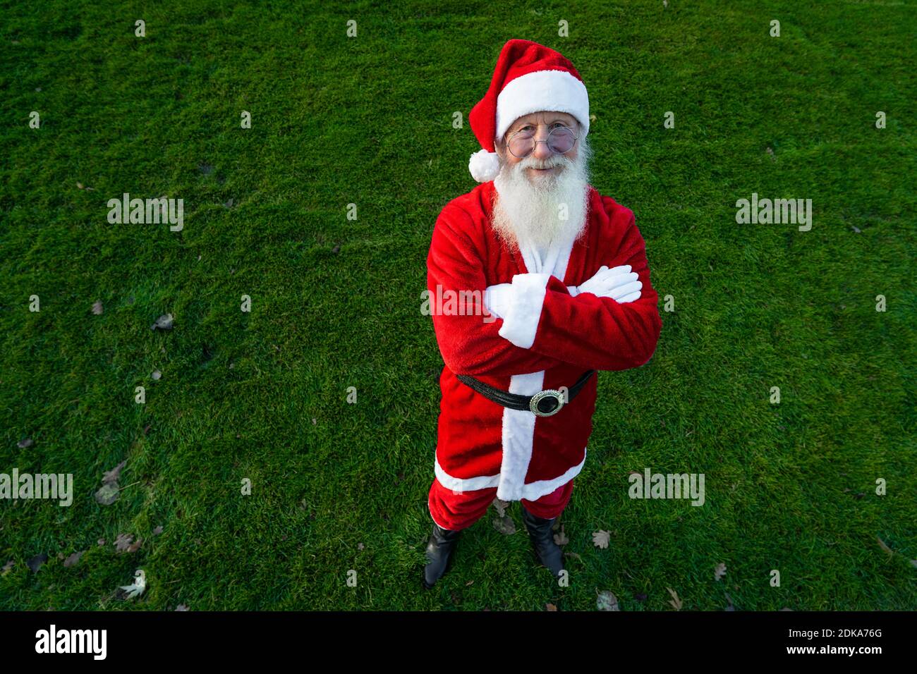 Funny Santa Claus wearing red costume in glasses while standing on the street Stock Photo