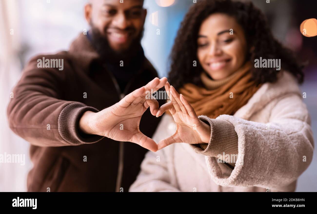 Portrait of black couple making heart shape with hands Stock Photo - Alamy