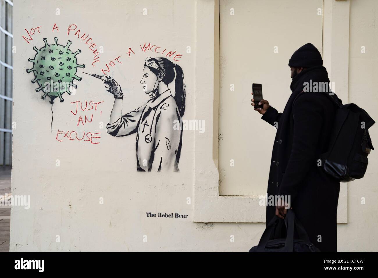 Edinburgh, Scotland, UK. 15 December 2020. Street art of Covid-19 vaccination by street artist The Rebel Bear in Edinburgh is vandalised by anti vaccination protestor. Iain Masterton/Alamy Live News Stock Photo