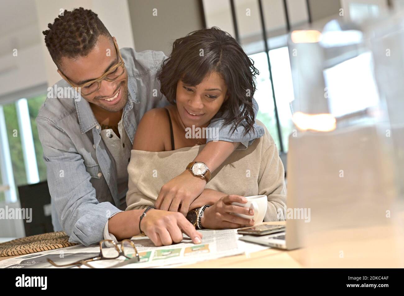 Young cheerful african american couple reading news Stock Photo - Alamy