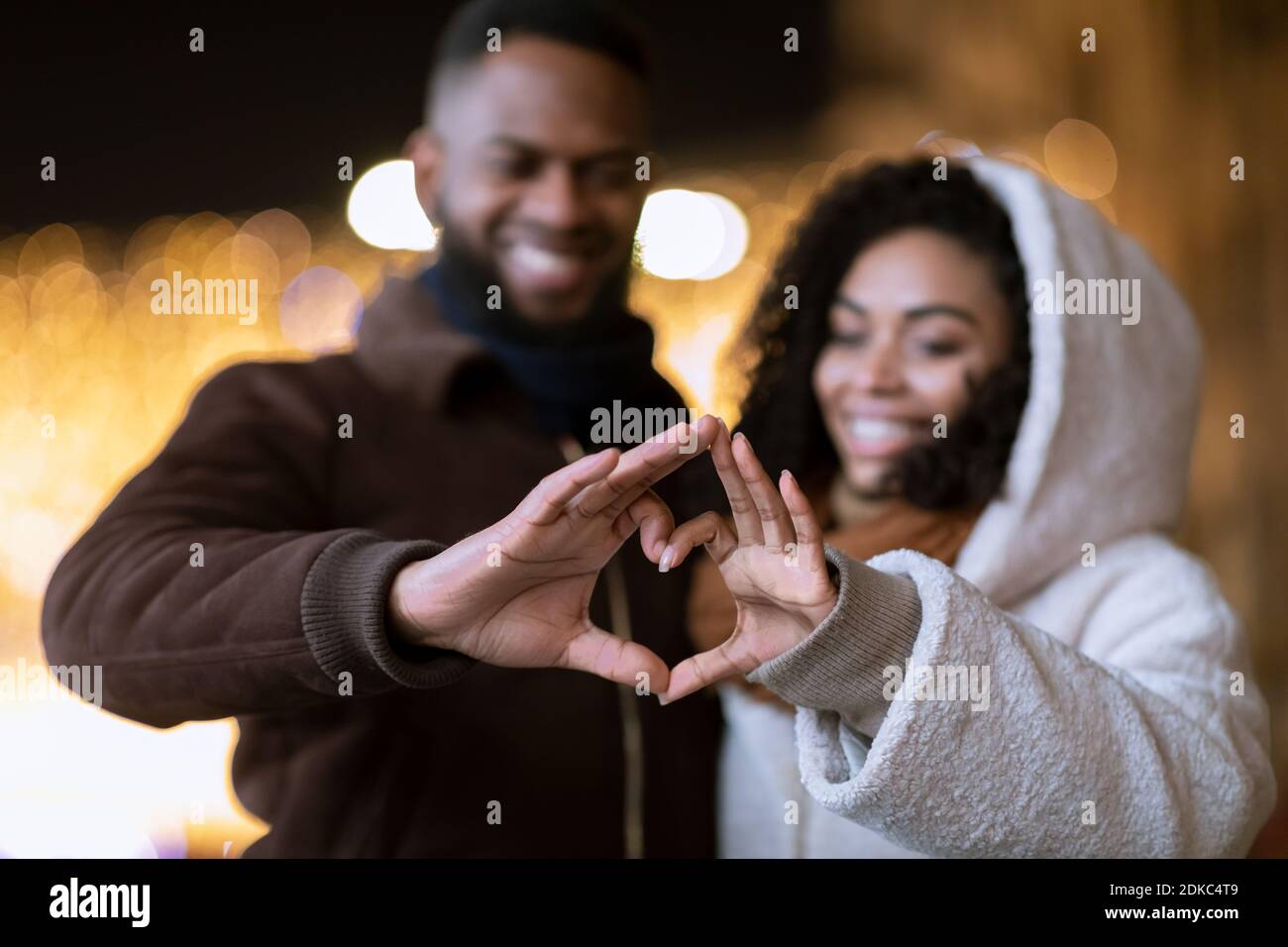 Portrait of black couple making heart shape with hands Stock Photo - Alamy