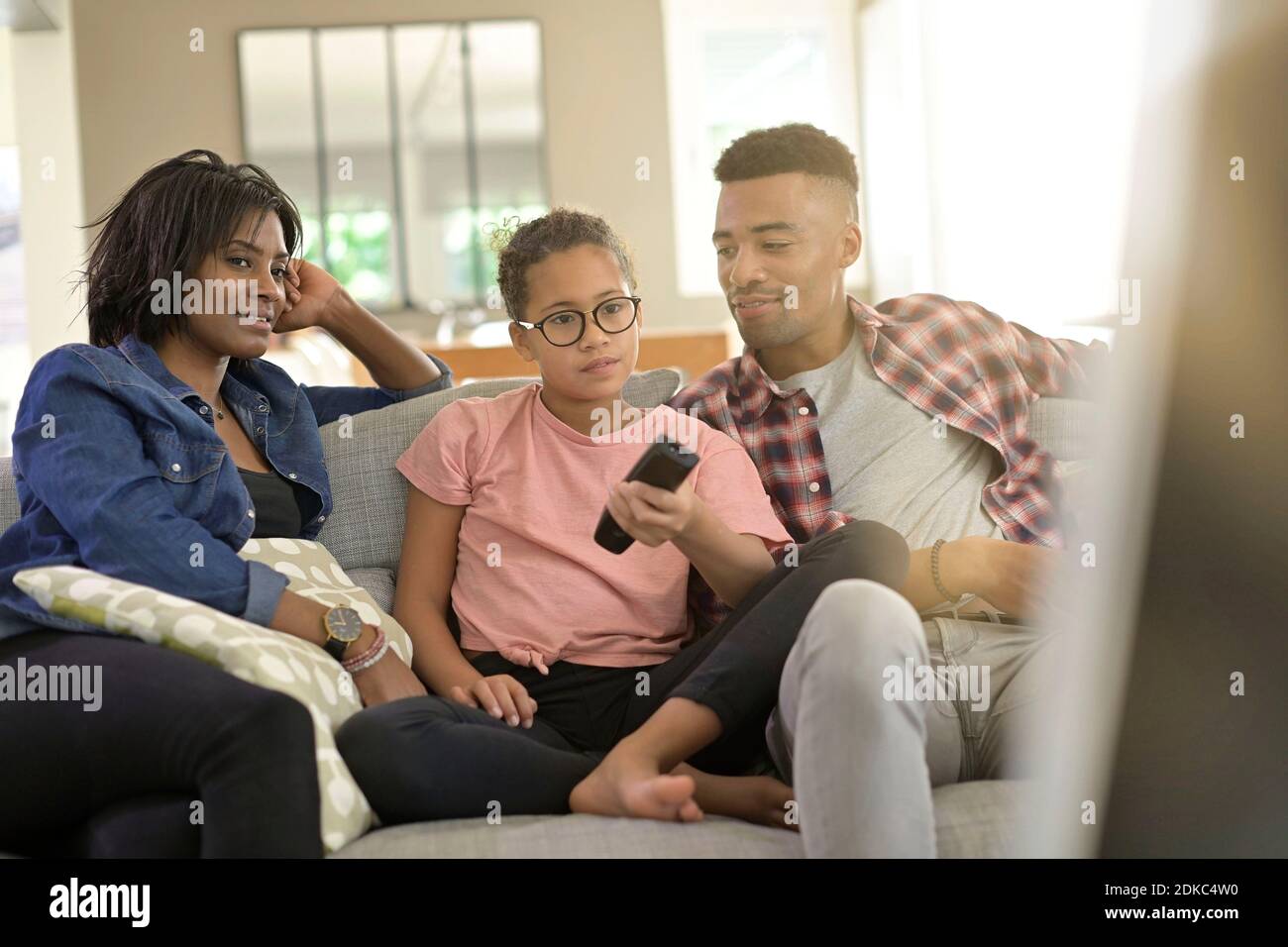 happy family sitting in sofa and watching tv together Stock Photo - Alamy