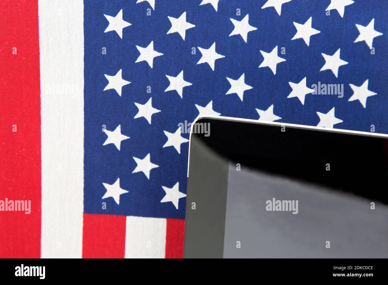 Remote learning and hybrid education are new alternatives in American schools shown with tablet and Stars and Stripes flag pattern Stock Photo