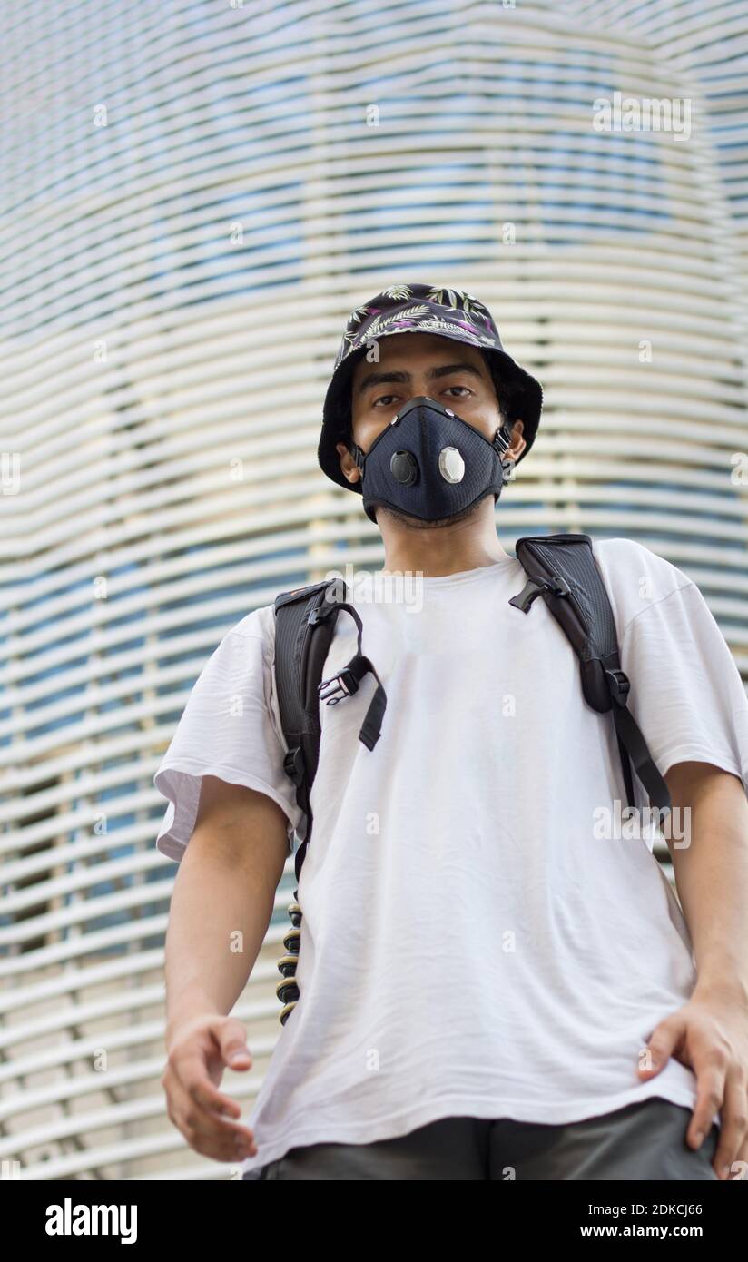 Man Wearing A Protective Mask To Avoid Coronavirus Infection Looking  Straight Wearing A Bucket Cap Stock Photo - Alamy