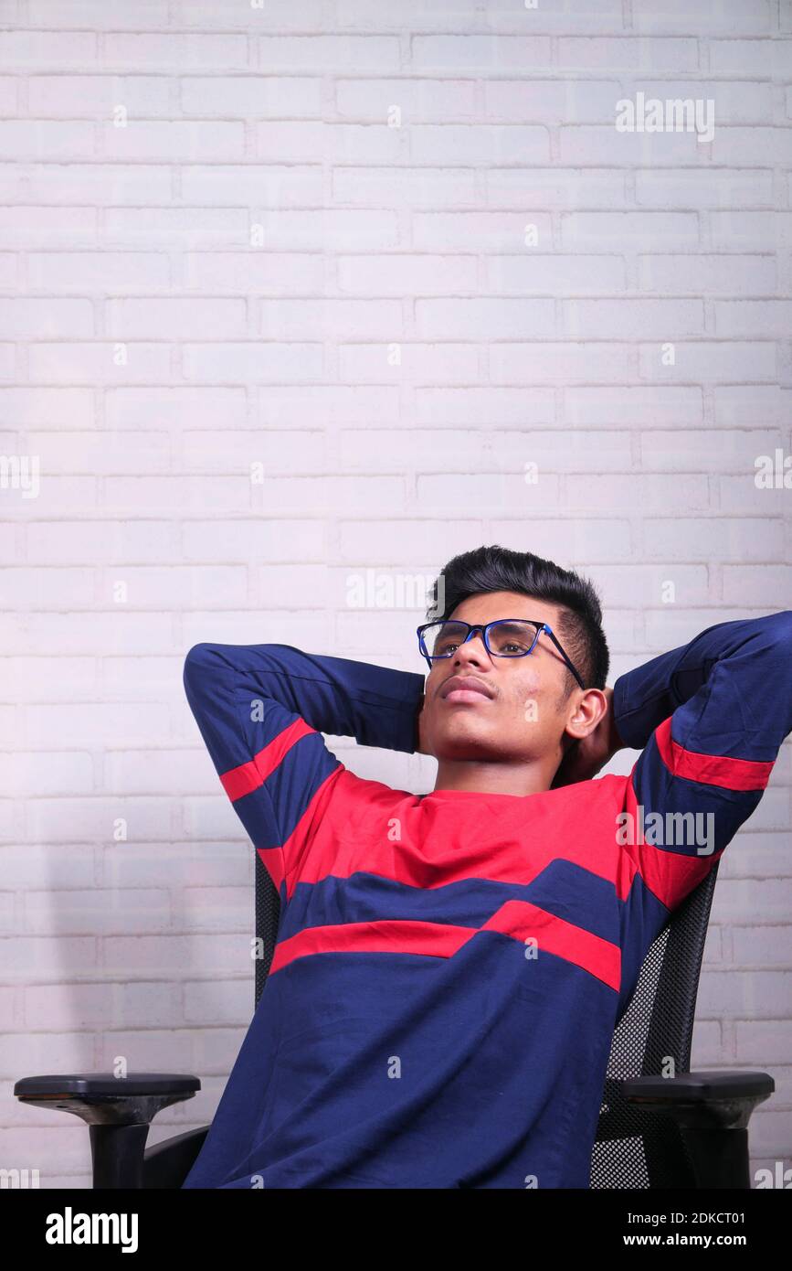 sad young man sits alone on a chair  Stock Photo