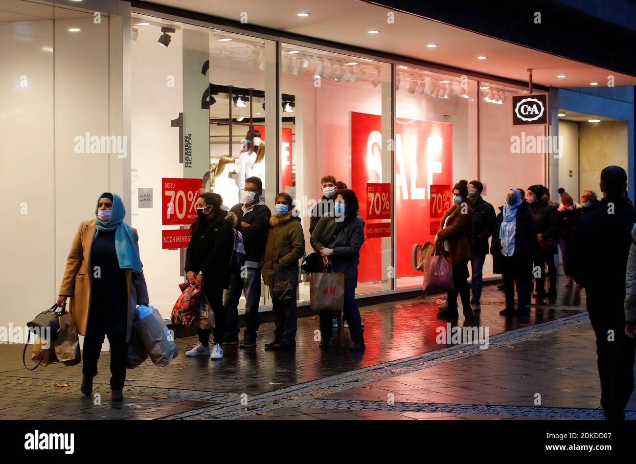 A woman leaves a C&A store as people queue outside one day before Germany  goes back to a complete lockdown due to the coronavirus disease (COVID-19)  outbreak, in Bonn, Germany, December 15,