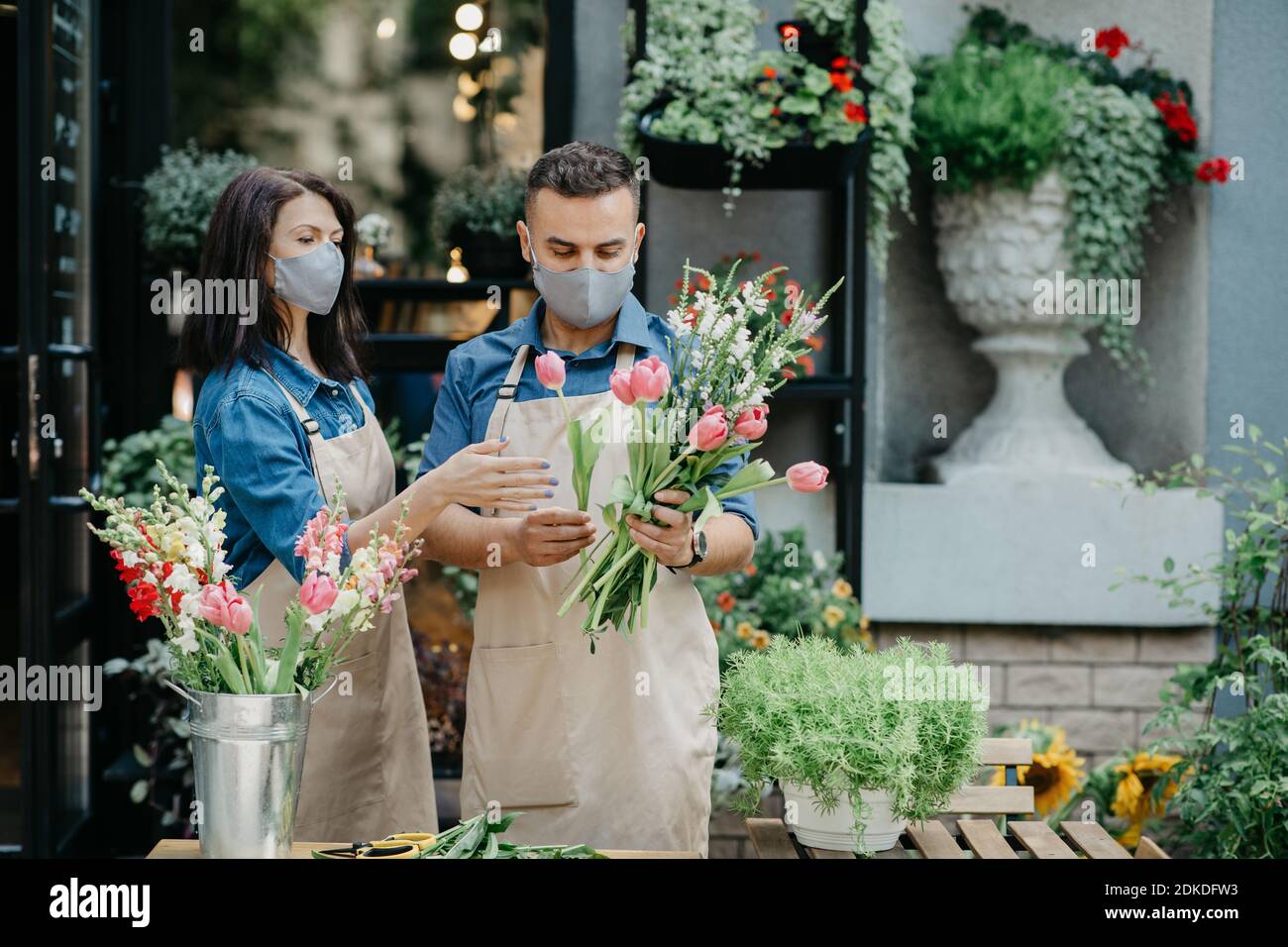 Florist creates composition of flowers. Young male and female small business owners make bouquet Stock Photo