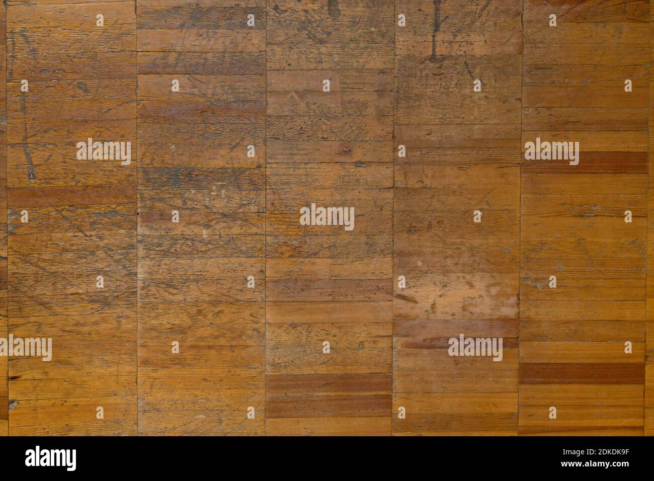 Texture background of old brown wooden parquet made of small boards close-up, with scratches, scuffs and cracks Stock Photo