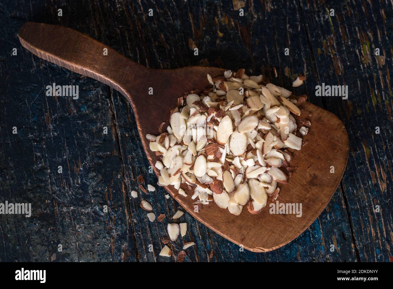 Close-up Of Chopped Almonds In Wooden Spoon On Table Stock Photo