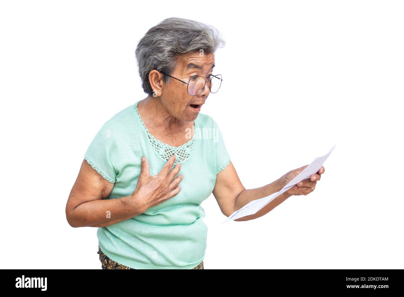 Surprised Senior Woman Looking At Paper Against White Background Stock Photo