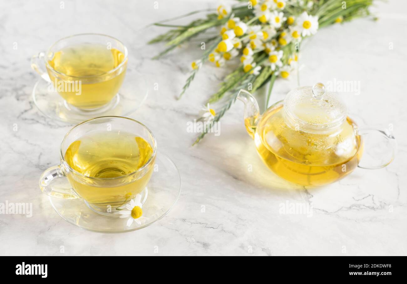 glass cups and teapot with chamomile tea on a white background. a bouquet of daisies Stock Photo ...