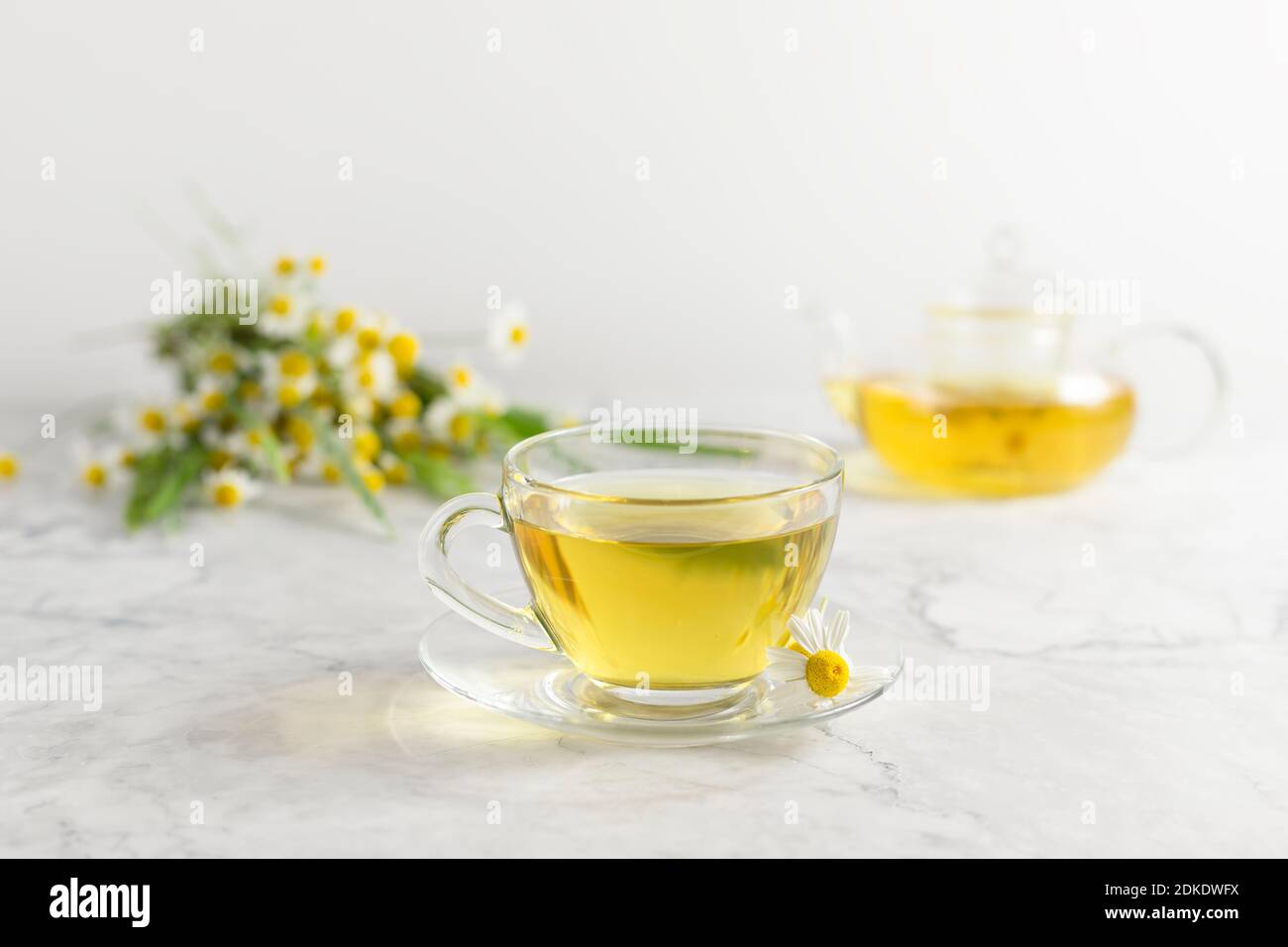 glass cups and teapot with chamomile tea on a white background. a bouquet of daisies Stock Photo ...