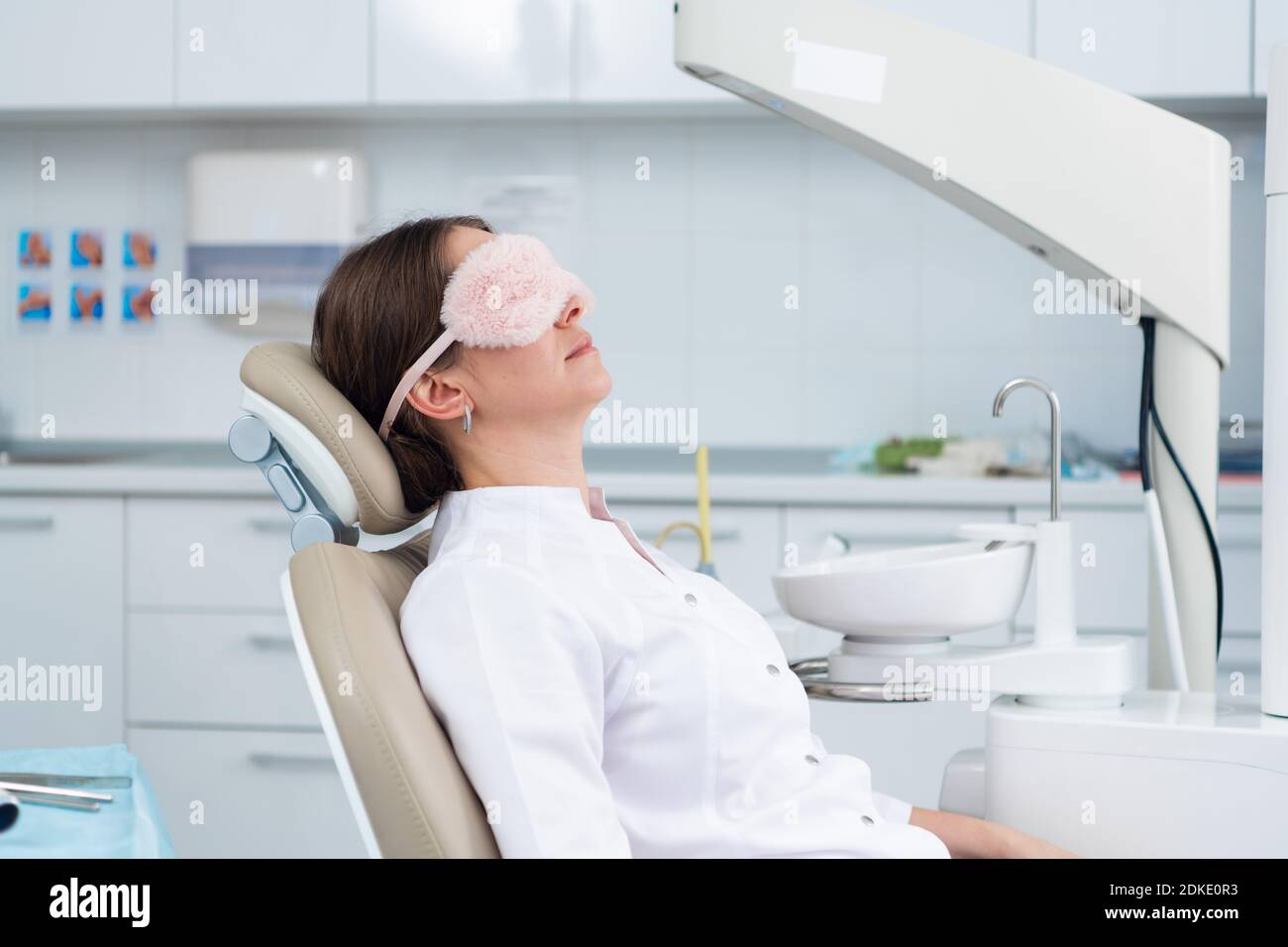 A doctor having a nap in the dental chair using a sleeping mask Stock