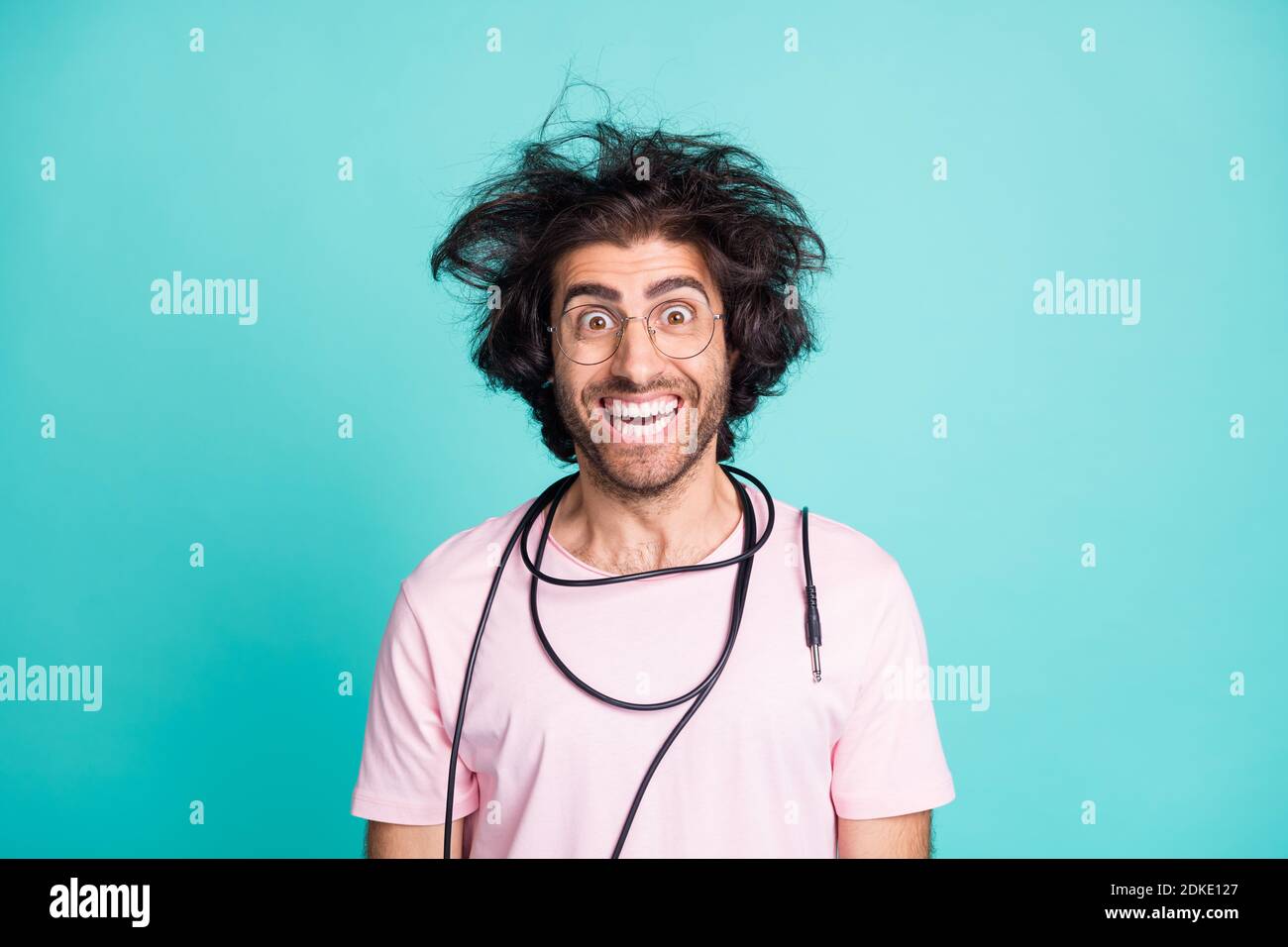 Portrait of weird hairdo cheerful person cord on neck good mood isolated on turquoise color background Stock Photo