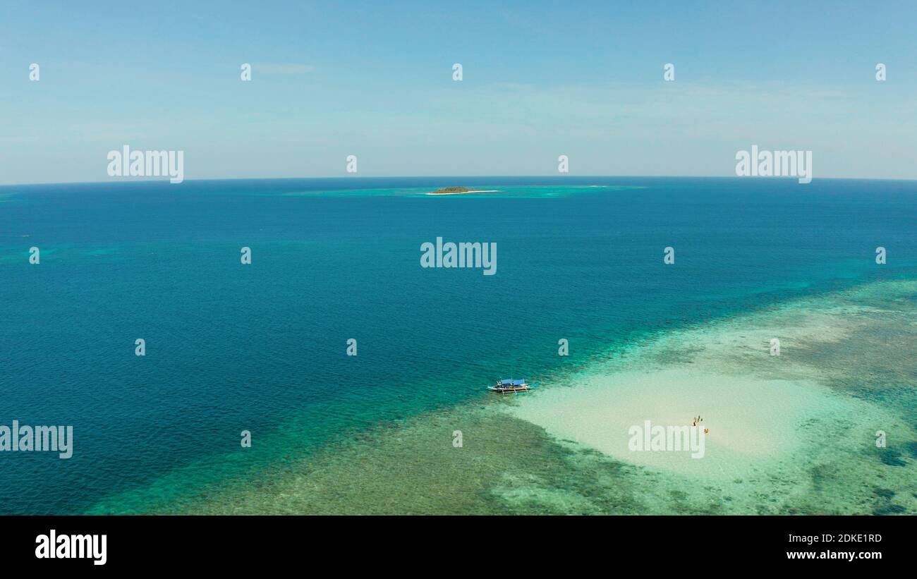 Sandy beach with tourists on a coral atoll in turquoise water, from above. Summer and travel vacation concept. Balabac, Palawan, Philippines. Stock Photo