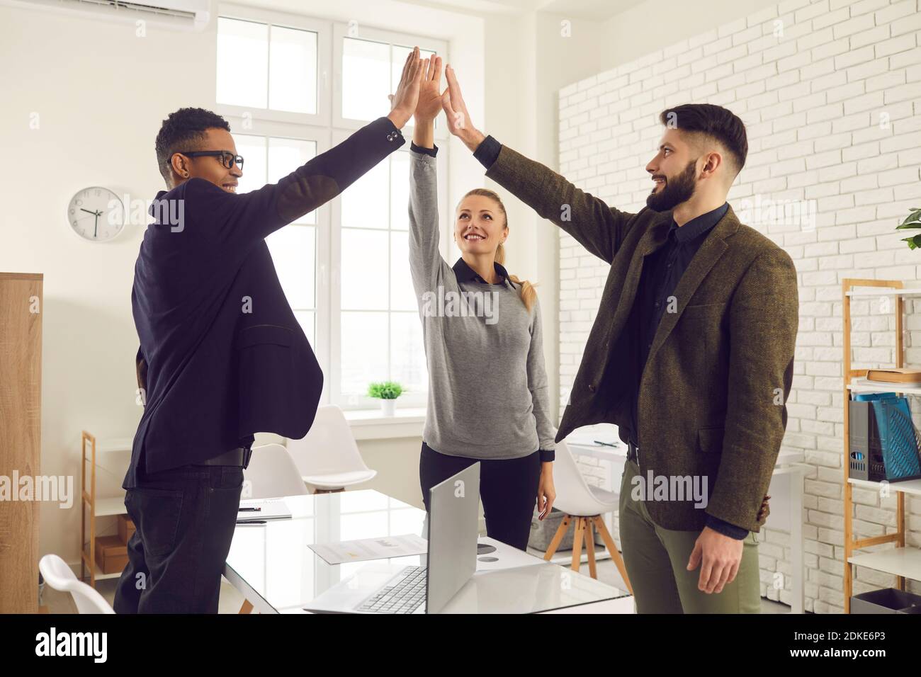 Happy young diverse sales team celebrating their teamwork and commercial success Stock Photo