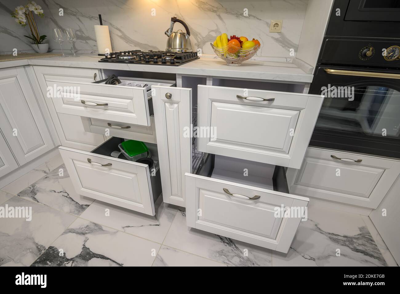 Open drawers with kitchenware at modern white kitchen Stock Photo - Alamy