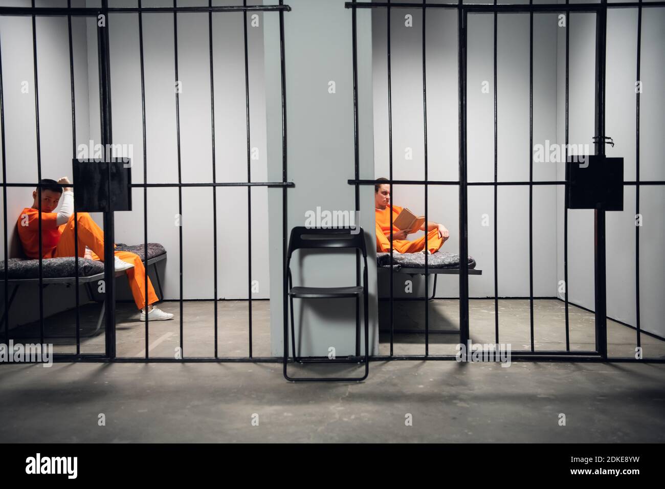 Prisoners in their cells are bored before lights out in prison. Read