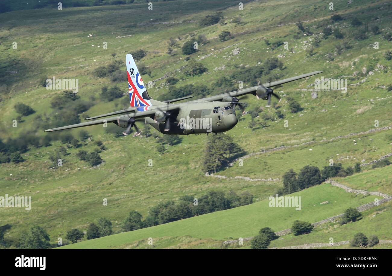 Low flying RAF C-130 Hercules, serial number ZH883.  Seen in Wales, in 2017, displaying a 50 years in-service commemorative tail livery. Stock Photo