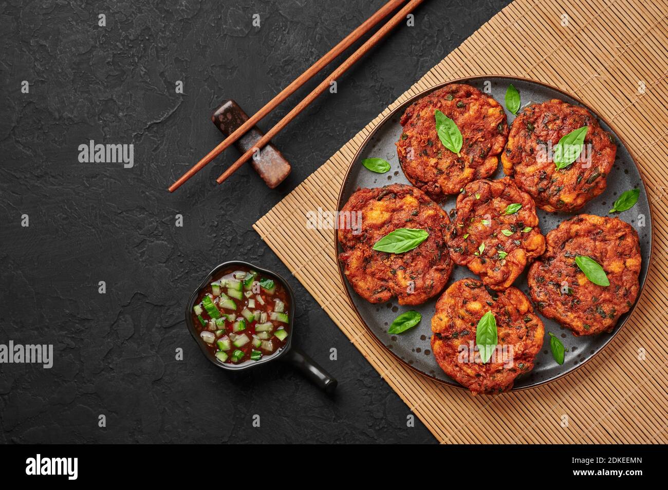 Tod Mun Pla or Thai Fish Cakes on black plate on dark slate table top. Traditional Thailand cuisine dish. Asian food and meal. Copy space. Top view Stock Photo