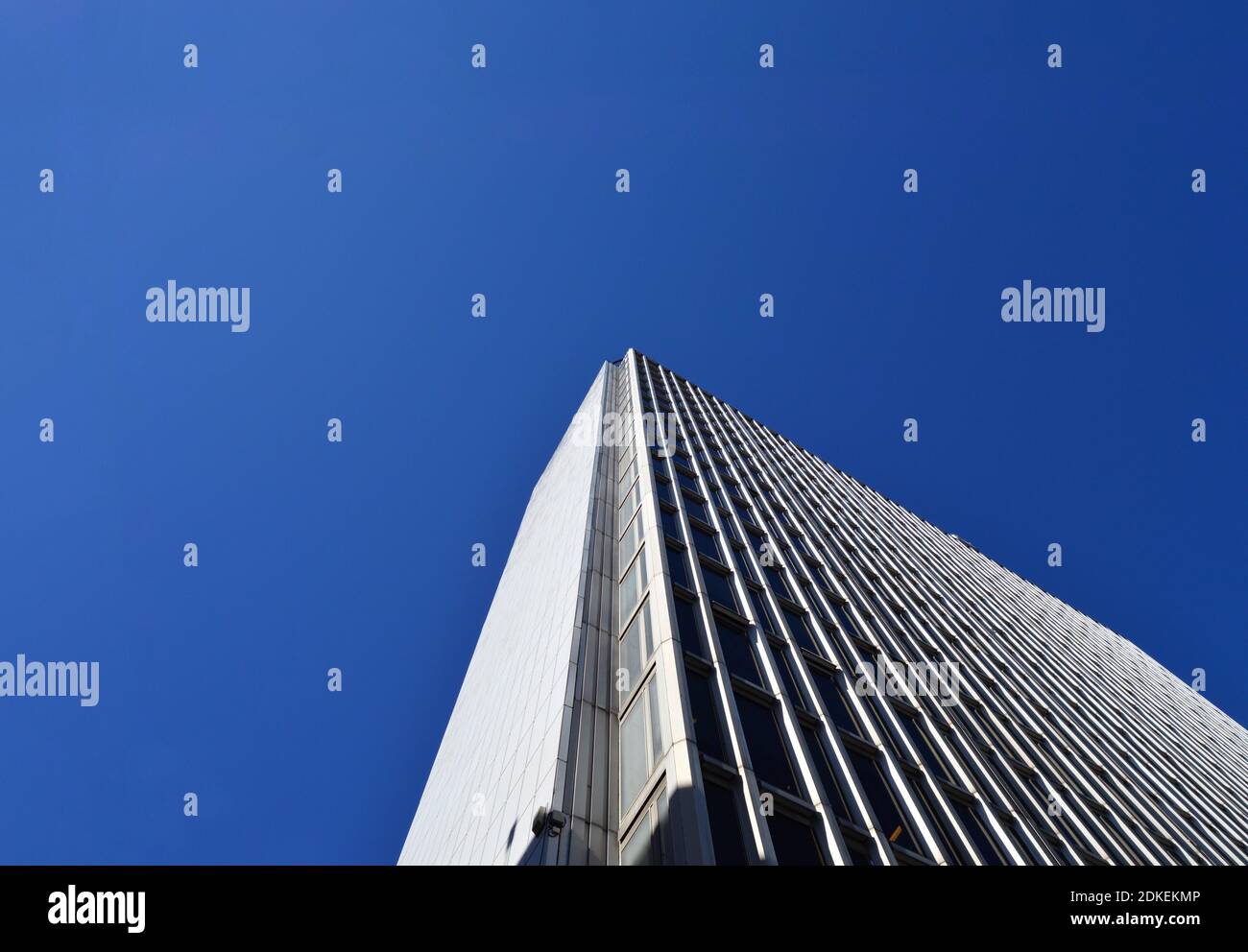 Low Angle View Of Modern Building Against Clear Blue Sky Stock Photo