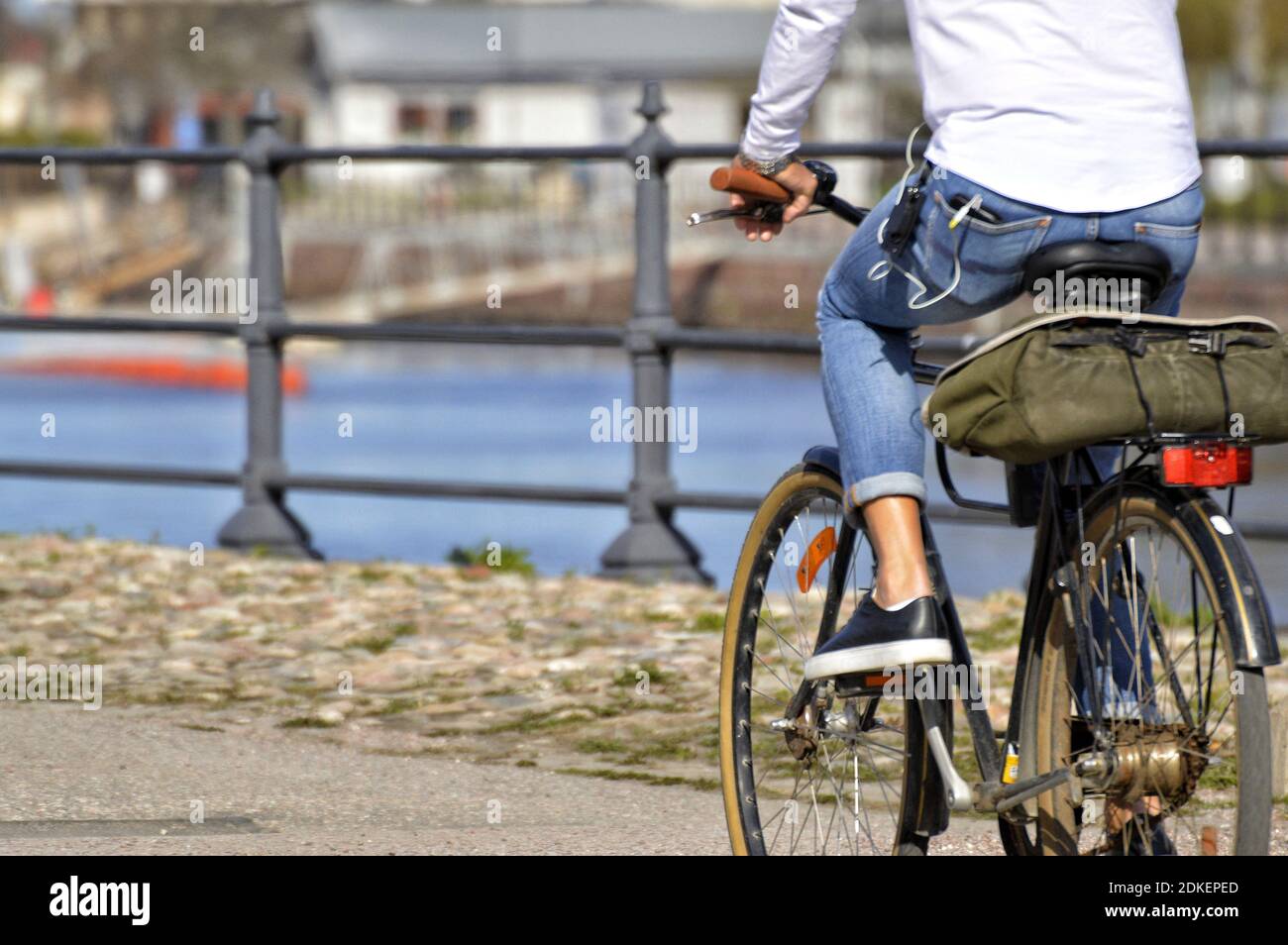 Low Section Of Man Riding Bicycle On Road In City Stock Photo