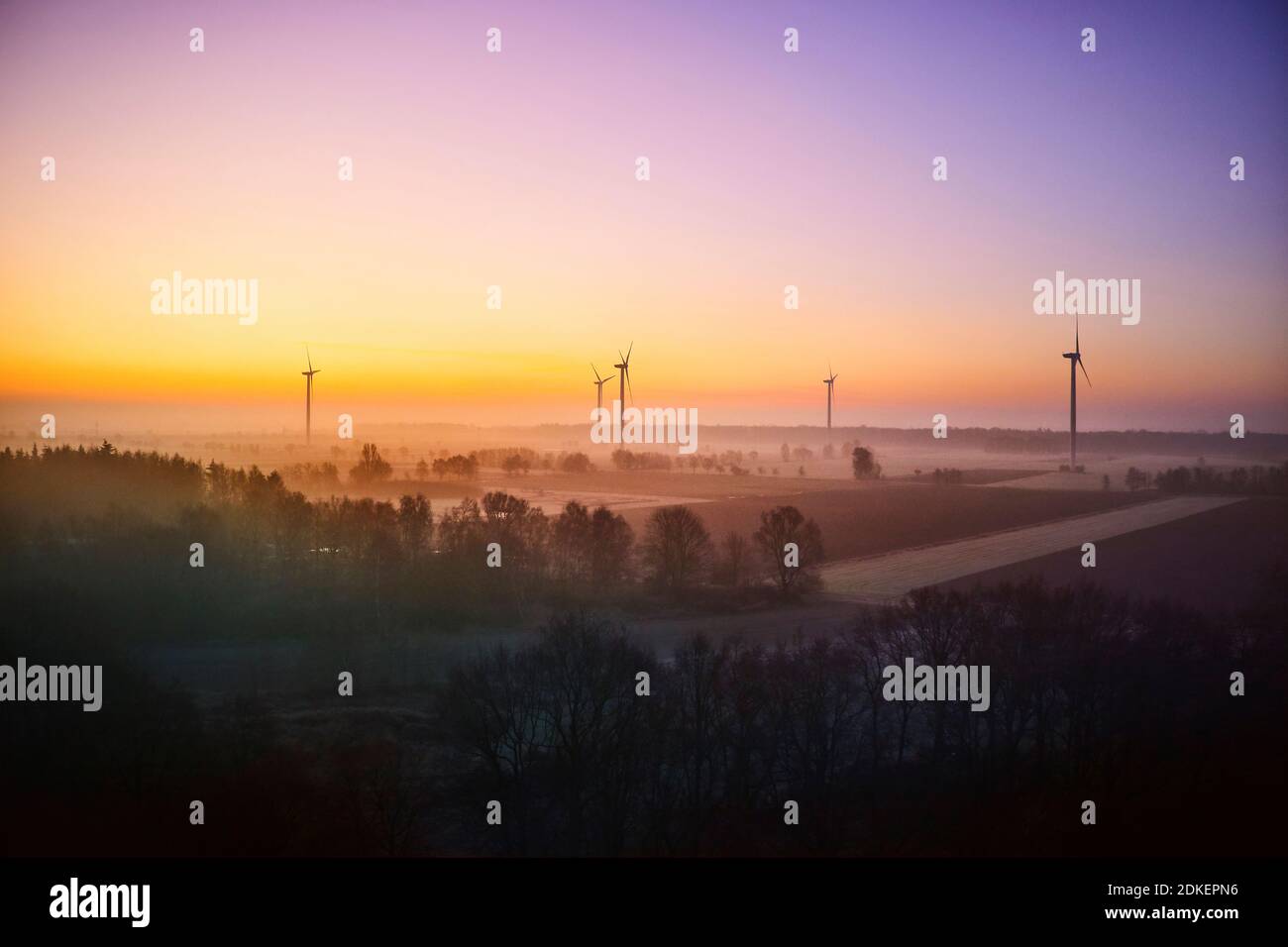 Landscape, Elbe Valley, Germany, Northern Germany, Lower Saxony, Elbe foreland near Hohnstorf, aerial view at sunrise, golden hour, colored sky, meadows in the morning mist, wind turbines Stock Photo