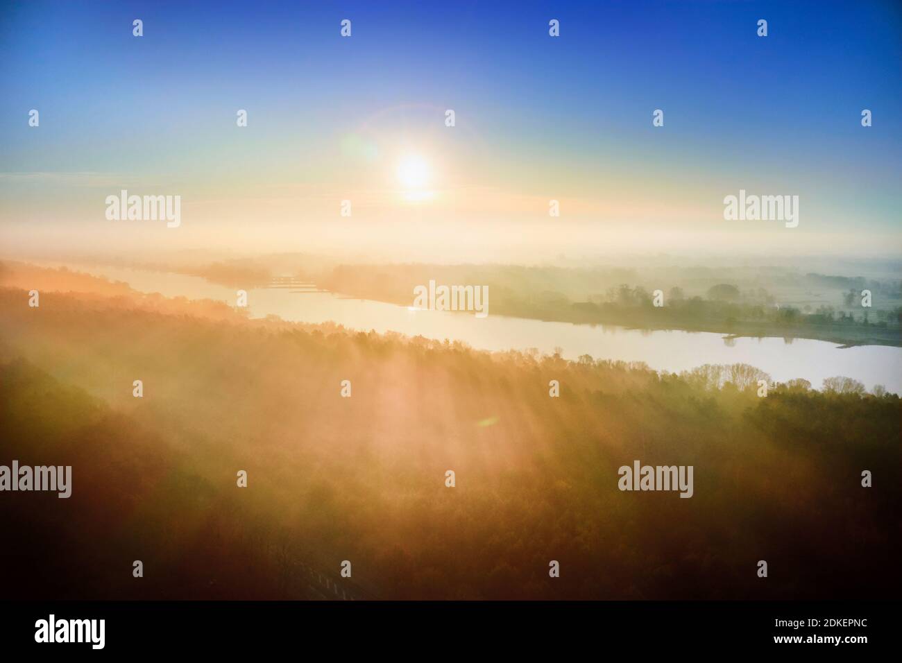Natural landscape, Germany, Northern Germany, Mecklenburg-Western Pomerania, Elbe near Lauenburg, aerial view at sunrise, golden hour, colored sky, forest and meadows in the morning mist, view towards Grünendeich in Lower Saxony Stock Photo
