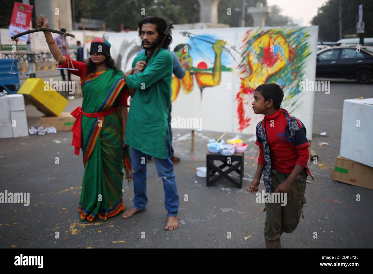 December 15, 2020: A street kid is looking at the performance artists while they were acting as the murals which were displaced on the demand and protest of radical muslim people of Bangladesh. Credit: Md. Rakibul Hasan/ZUMA Wire/Alamy Live News Stock Photo