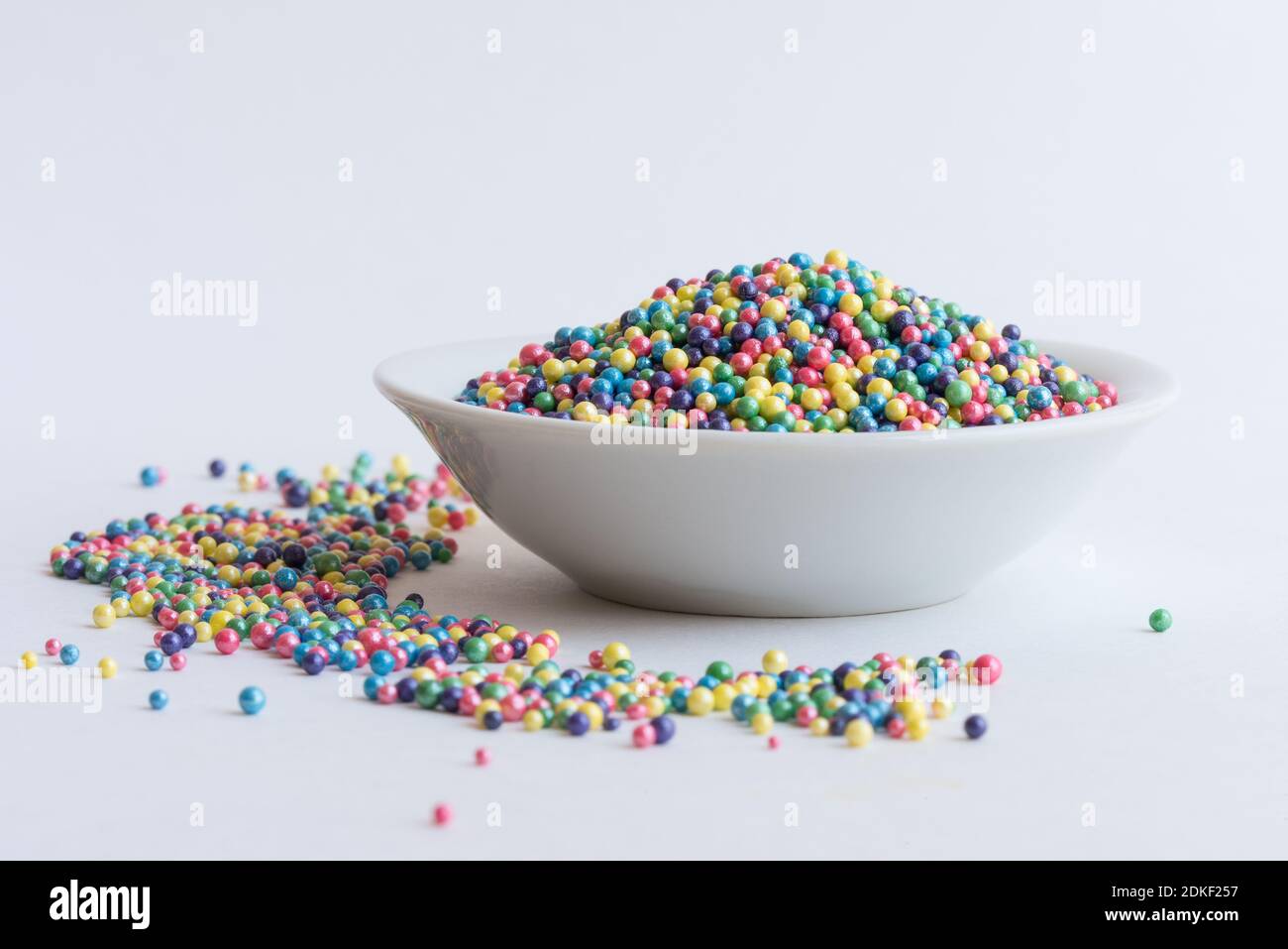 Multi Colored Sprinkles In Bowl On White Background Stock Photo
