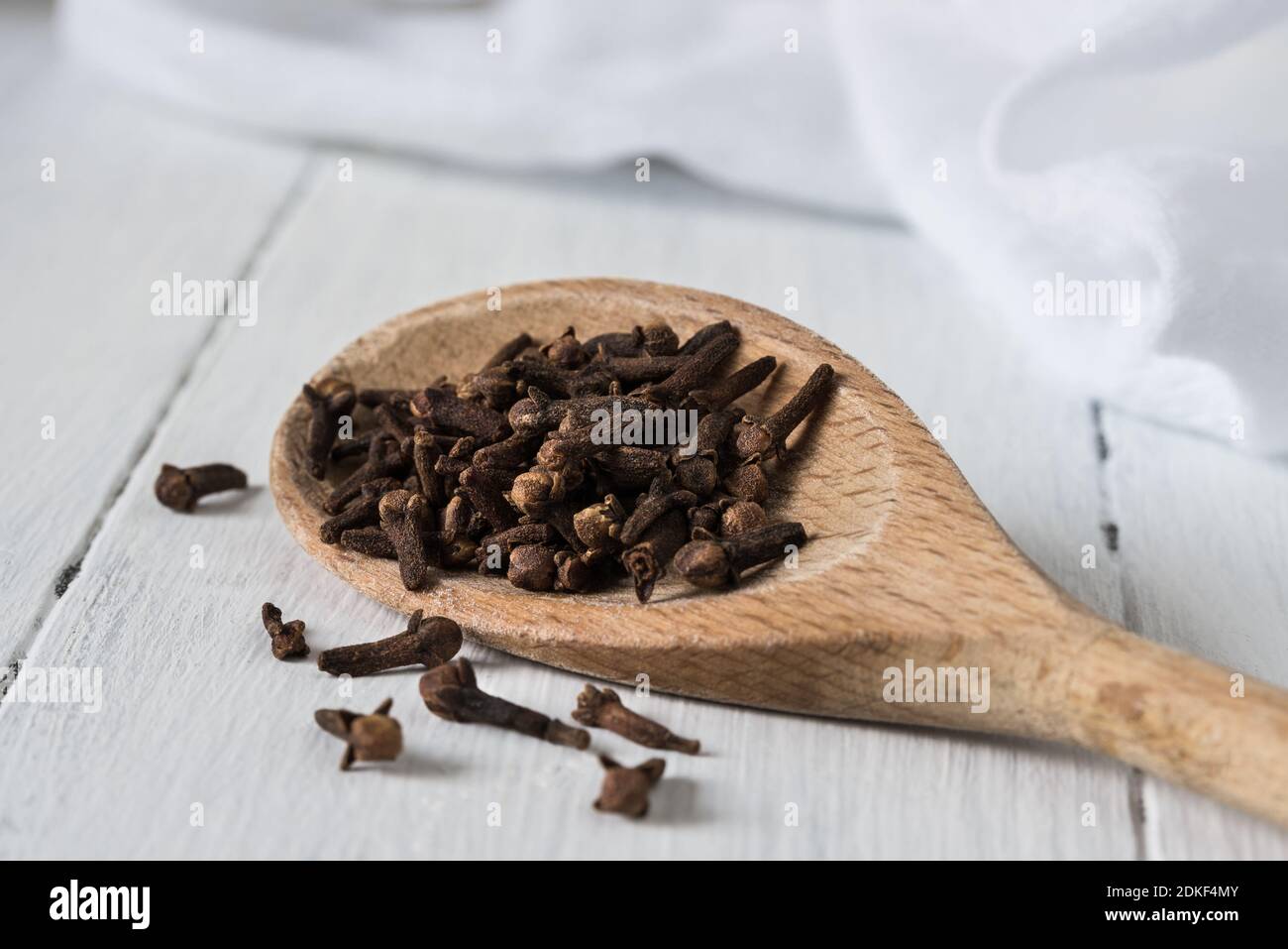 Close-up Of Cloves With Wooden Spoon On Table Stock Photo