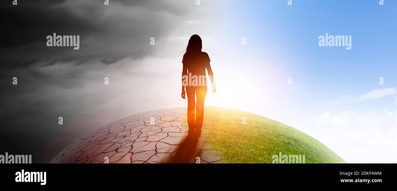 Woman on a globe from darkness into light Stock Photo