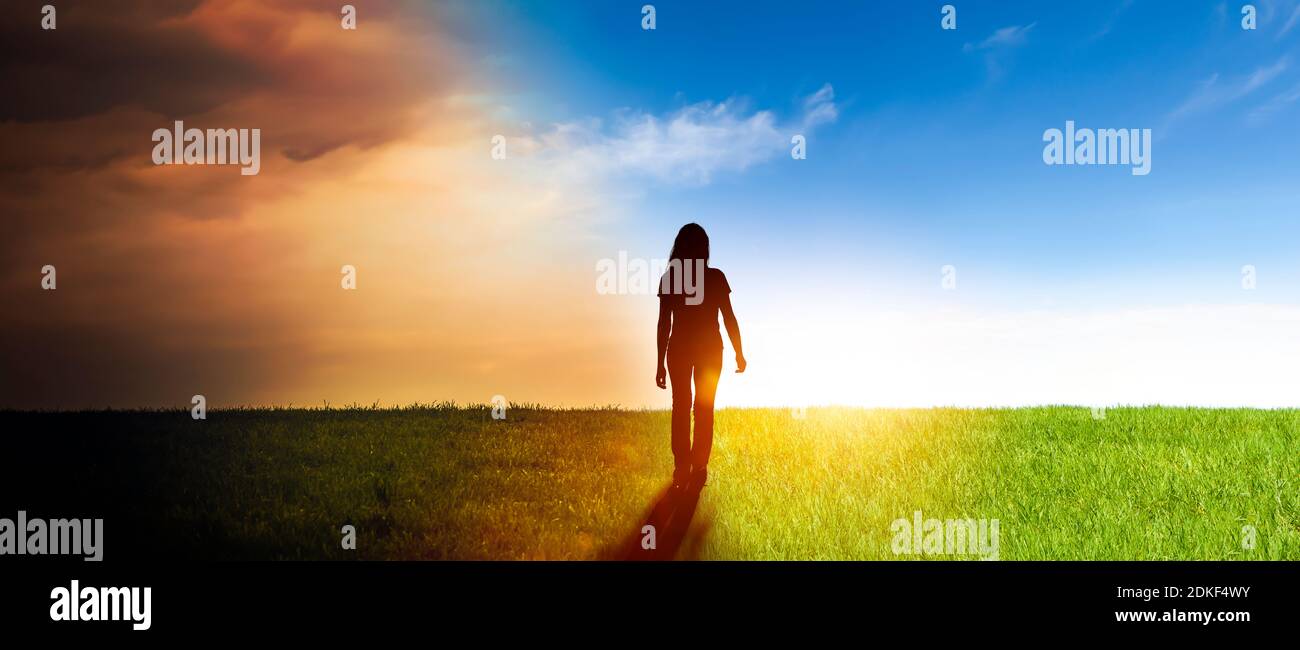 Woman in a landscape, symbol - from darkness into light Stock Photo