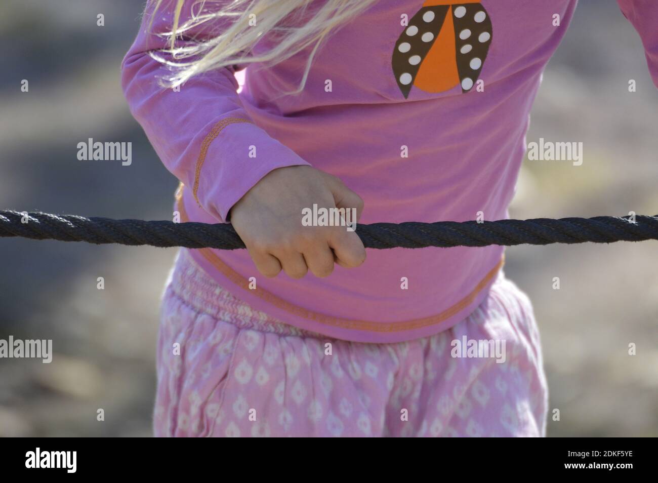 Midsection Of Girl Holding Rope Stock Photo