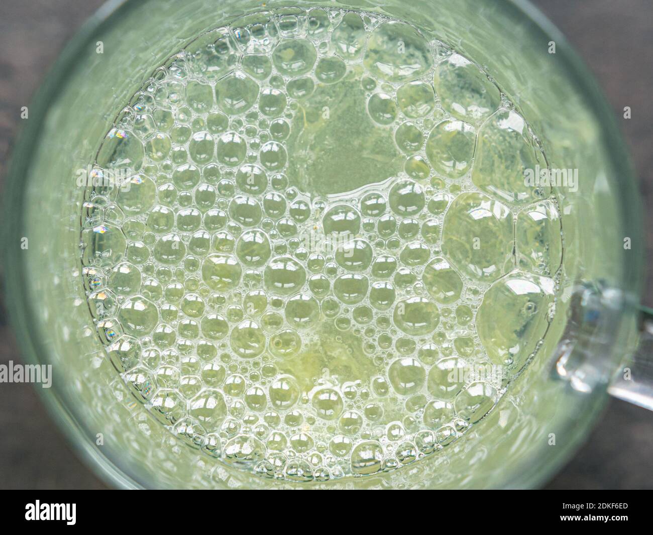 Photo from above of bubbles in lemon juice contained in a glass Stock