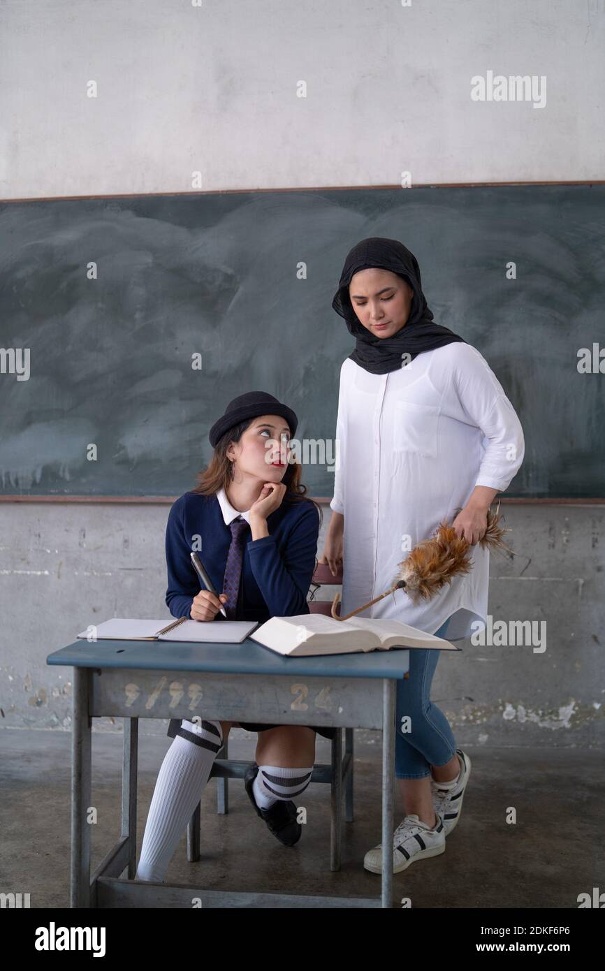 student paying attention to malay teahcer in a class room Stock 
