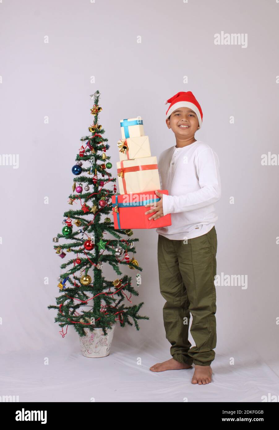 Cute Indian boy or kid holding christmas gifts. Stock Photo