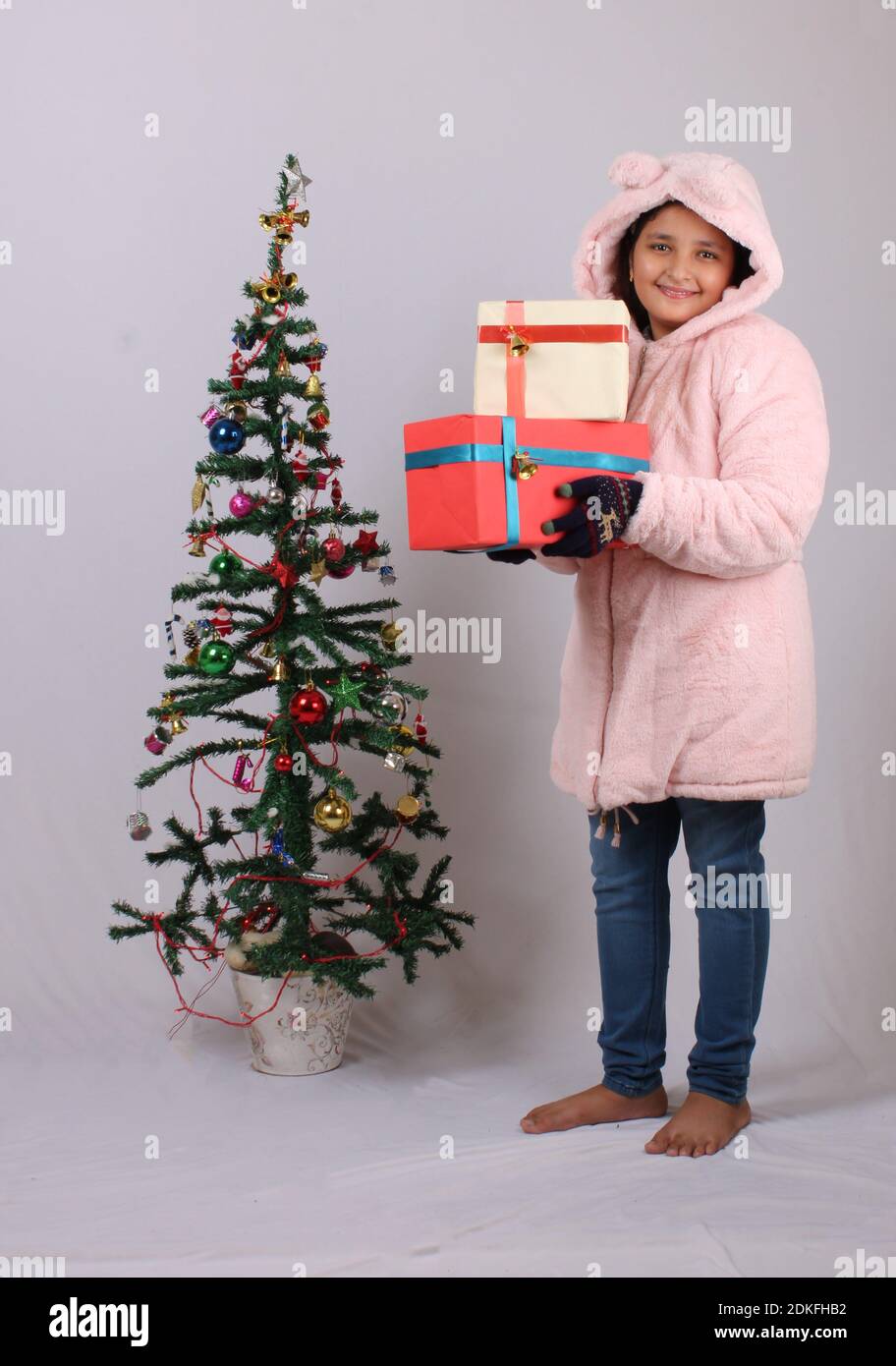 Cute little Indian girl with Christmas gift. Stock Photo