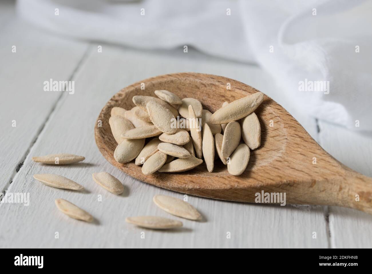 Close-up Of Pumpkin Seeds With Wooden Spoon On Table Stock Photo