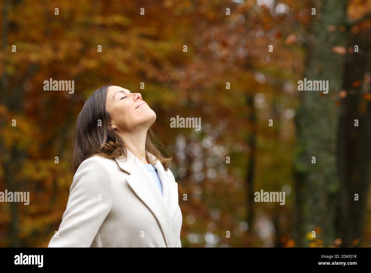 Adult woman breathing fresh air standing in a park in autumn Stock ...