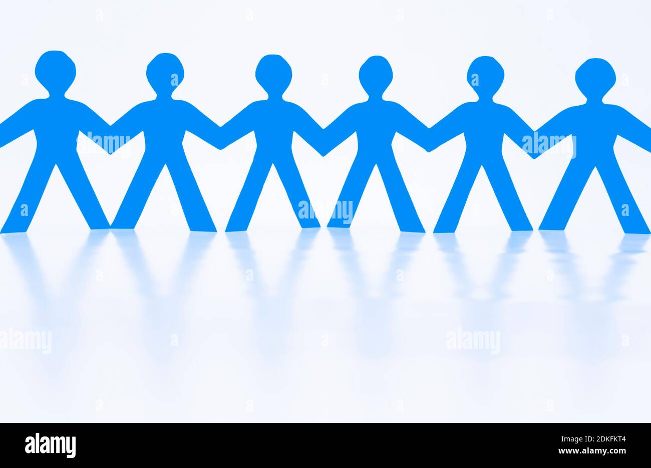 Paper man as a human chain against a white background Stock Photo - Alamy