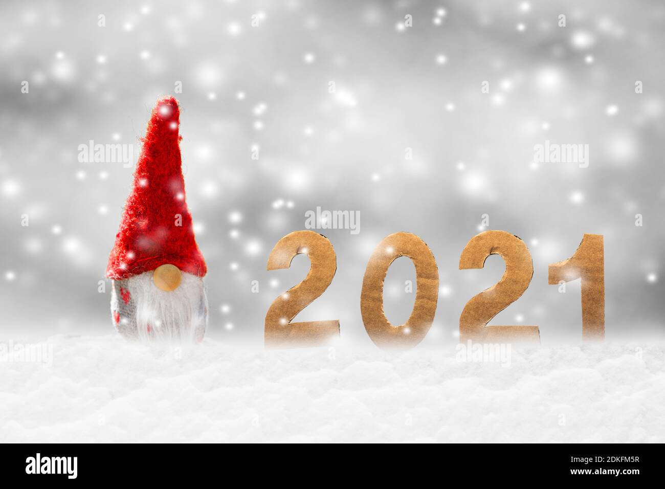 Little Santa Claus in the snow with the year 2021 Stock Photo